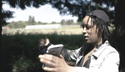 Black female director talking expressively in an outdoor location.